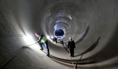 工作人员正在向家坝灌区北总干渠一期工程龙洞岩隧洞工程内检查电缆